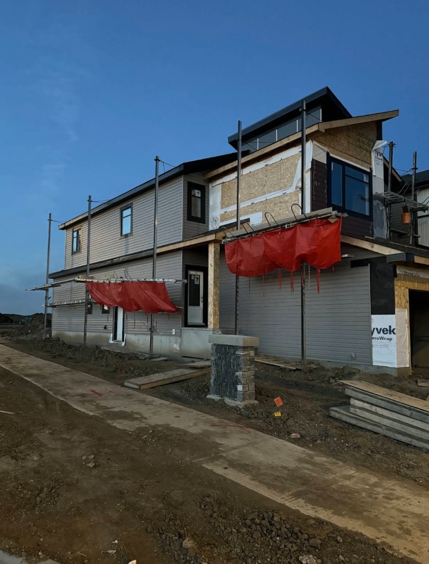 Two-storey suburban house with fresh white board-and-batten fibre cement siding and black trim
