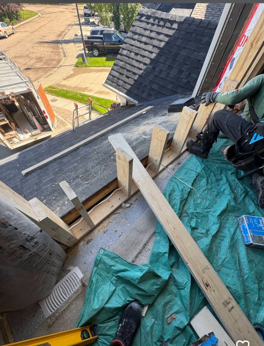 Close-up of a precisely mitred cedar soffit meeting dark fibre cement siding with aligned reveal lines